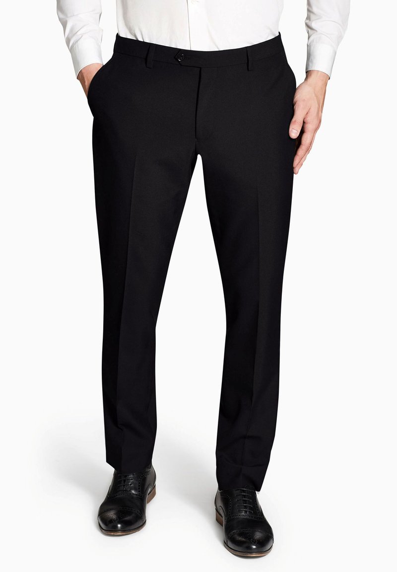 Pantalones negros ajustados con un frente plano, que cuentan con dos bolsillos laterales y un cierre de botón. Tejido suave y tejido con un acabado limpio.