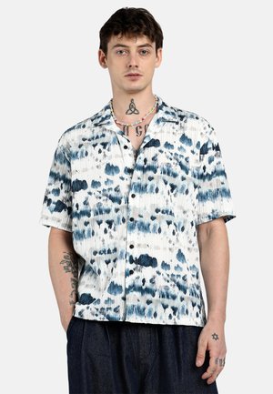 Short-sleeve button-up shirt in white with blue and gray tie-dye patterns. Features a relaxed fit and collar, with a textured fabric finish.