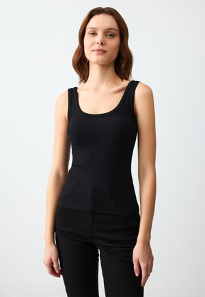 Débardeur noir à côtes avec larges bretelles et encolure en scoop, silhouette ajustée, fabriqué à partir d'un mélange de coton extensible.