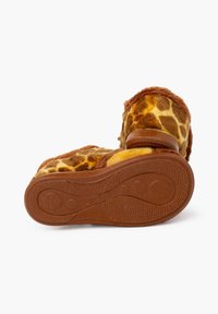 Pantofole pelose con motivo a giraffa, dotate di un morbido esterno giallo e marrone, suola in gomma e grip texturizzato per garantire stabilità.