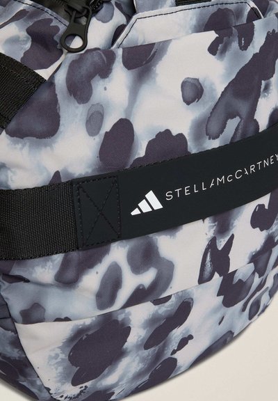 Σακίδιο πλάτης με μαλακό, διακοσμητικό ύφασμα σε γκρι και μαύρο, με μαύρο ιμάντα που φέρει το λογότυπο "STELLA McCARTNEY" σε λευκό. Υφή επιφάνειας.