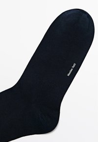 Granatowa skarpeta wykonana z gładkiego materiału, z zaokrąglonym czubkiem i ściągaczem. Nazwa marki "Massimo Dutti" jest nadrukowana na biało.