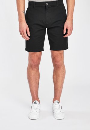 Schwarze Shorts aus Baumwollmischgewebe, mit flachem Bund, Knopfverschluss und Seitentaschen. Gesäumte Kanten und eine maßgeschneiderte Passform.