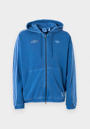 Sweat-shirt à capuche bleu avec fermeture éclair complète, cordons de serrage, poches avant, trois bandes bleu clair sur les manches, et logo Adidas sur la poitrine et les étiquettes.