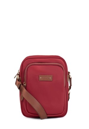 Petit sac bandoulière rouge compact avec poche zippée à l'avant, sangle marron réglable et quincaillerie dorée.