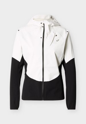 Λευκό και μαύρο μπουφάν με φερμουάρ και κουκούλα, μακριά μανίκια και μικρό λογότυπο στην αριστερή πλευρά του στήθους.