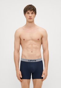 Námorníckomodré boxerky vyrobené z mäkkej tkaniny, s kontrastným elastickým pásom s logom "Levi's" a priliehavým strihom.