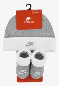 Il set Nike per neonati è composto da un berretto a maglia grigio con risvolto bianco e scarpine grigie coordinate, entrambi con il logo Nike in bianco.