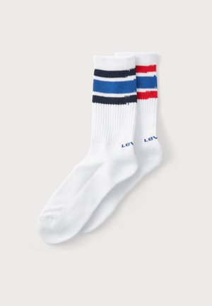 Valged puuvillased sokid ribakujundusega, millel on kaks horisontaalset triipu tumesinises ja punases. "Levi's" on sinise värviga trükitud sääre lähedal.