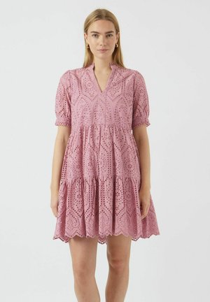 Rochie din bumbac roz, cu detalii brodate în puncte, mâneci scurte tip puff, decolteu în V și fustă stratificată care se termină deasupra genunchiului.