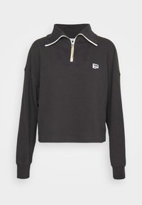 Pullover corto nero con maniche lunghe, tessuto testurizzato, colletto alto e chiusura con mezza zip. Presenta un piccolo logo bianco sul petto.