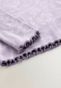 Levandulový žebrovaný materiál s vroubkovaným okrajem; má květinový vzor a jemnou texturu. Pohled na detail a design zblízka.