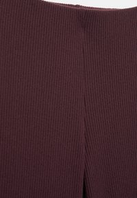 Tissu tricoté côtelé violet foncé avec une couture verticale au centre.
