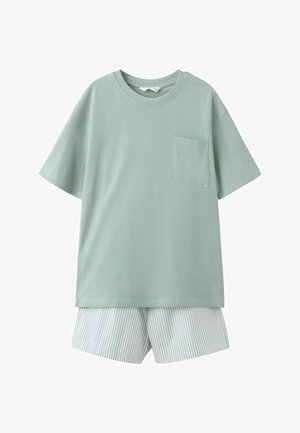 Svetlozelené tričko s krátkym rukávom a náprsníkom v kombinácii so svetlomodrými a bielo pruhovanými šortkami s vertikálnymi pruhmi.