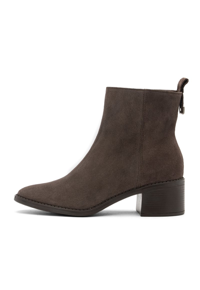 Stivale alla caviglia in suede marrone con punta a punta, tacco basso a blocco e dettagli con zip sul retro. Design semplice con sottili accenti di cucitura.