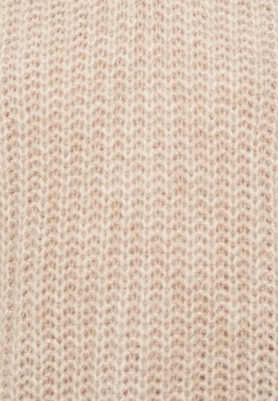 Strickstoff in sanften Beigetönen, mit einem lockeren, strukturierten Muster und sichtbaren Fasern, das ein gemütliches, leichtes Aussehen erzeugt.