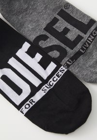 Black and gray cotton socks featuring large white text. Black sock reads "DIESEL" and gray sock states "FOR SUCCESSFUL LIVING."