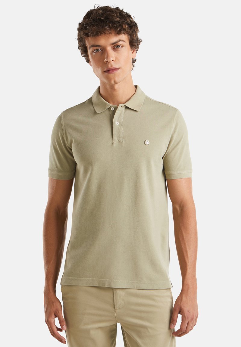 Polo de color verde claro, hecho de algodón texturizado, con cuello clásico, mangas cortas y un pequeño logo bordado en el pecho.