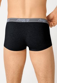 Shorts boxer Sloggi neri con una texture liscia e lunghezza corta. Fascia elastica grigia con testo logo bianco lungo il bordo superiore.