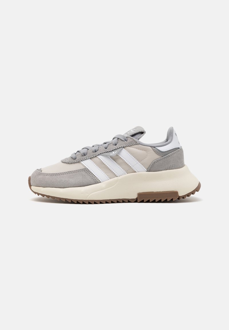 Grauer Sneaker aus Wildleder und Textil mit weißen Streifen, gepolstertem Schaft und einer mehrschichtigen, creme- und braunen Gummisohle mit strukturiertem Profil.