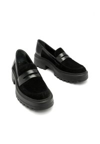 Czarne loafersy z zamszową cholewką i gładką skórzaną wstęgą. Masywna gumowa podeszwa. Cechuje je minimalistyczny design z lekko podniesioną piętą.