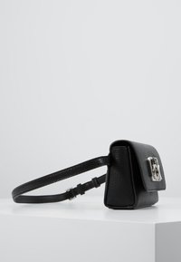 Czarna, teksturowana, skórzana torba na ramię w kształcie prostokąta, z zamknięciem na srebrnych akcesoriach i regulowanym paskiem.