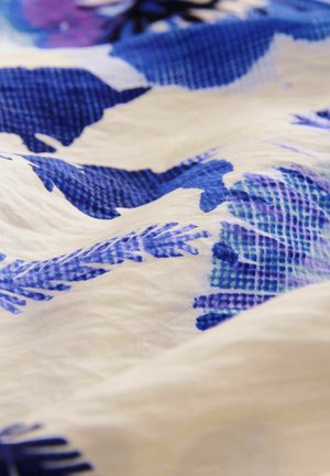 Virágmintás szövet különböző kék árnyalatokban, fehér háttéren, textúrázott mintákkal és puha, sima felülettel.