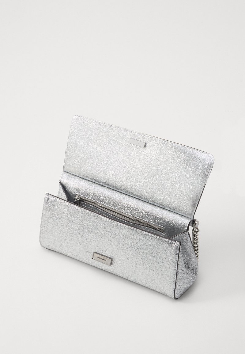 Clutch argentato in metallo con una superficie liscia e scintillante. Dotato di una tracolla a catena e di un compartimento interno con zip. Forma rettangolare compatta.