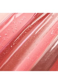 Glänzende, transparente pinke und rote Gelstreifen mit kleinen Luftbläschen und schimmernden Partikeln, die in diagonalen Linien angeordnet sind.
