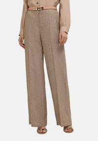 Ljusbruna, vida byxor med vertikala ränder, tillverkade av textil med struktur, med en figursydd midja och ett slätt beige bälte.