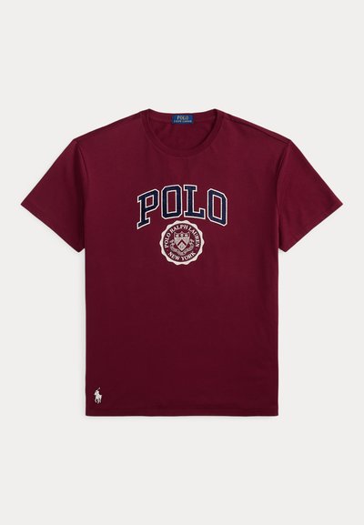 Μπορντό κοντομάνικο T-shirt με κείμενο "POLO" και το έμβλημα Polo Ralph Lauren New York τυπωμένο στο μπροστινό μέρος, καθώς και μικρό λογότυπο αλόγου κοντά στο κάτω τελείωμα.