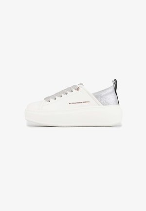 Witte leren sneaker met zilveren accenten, dikke witte zool, grijze veters en een zwarte lus aan de achterkant. Logo weergegeven aan de zijkant.