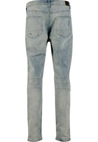 Jeans azul claro de corte ajustado, con un lavado ligeramente desgastado, cinco bolsillos y detalles de costura a lo largo de las piernas.