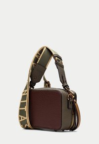 Borsa a tracolla in pelle verde e marrone con una finitura testurizzata, hardware dorato e una tracolla decorata. Forma rettangolare compatta con zip.
