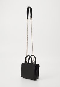 Black faux leather handbag with dual handles, gold-tone chain strap, structured shape, smooth texture, and minimalist design.