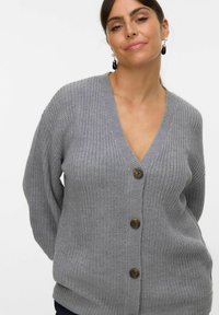 Cárdigan gris de punto con escote en V, cinco botones grandes marrones, mangas largas y un corte relajado, con tejido texturizado.