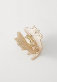 Clip per capelli in plastica translucida color pesche con decorazioni in oro e strass, caratterizzato da un design a forma di farfalla e un meccanismo a molla.