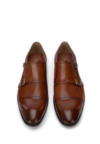 Zapatos de cuero marrón con un patrón de espiga texturizado, doble hebilla, punta redondeada y un acabado suave en la puntera y el tacón.