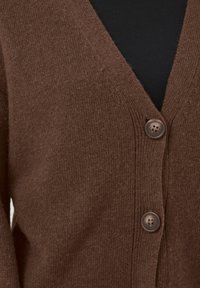 Brown knitted cardigan with a V-neck, featuring two round, brown buttons and a soft texture. Visible stitching details enhance the design.