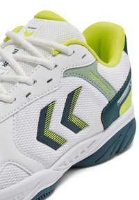 Białe buty sportowe z teksturowaną cholewką z siateczki z zielonymi akcentami. Charakterystyczne detale to dwa logotypy w kształcie szewronu i wyściełany kołnierz.