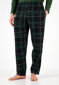Pajama pants w kratkę z flaneli w zielonym i czarnym kolorze, z elastycznym pasem, bocznymi kieszeniami i białymi detalami w kratę. Miękka tekstura.