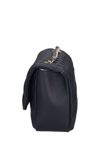 Borsa a tracolla nera in pelle trapuntata vista di lato, con chiusura a pattina e dettaglio della catena in tonalità dorata sulla parte superiore.