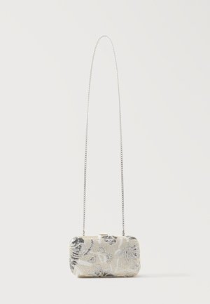 Ορθογώνιος ασημένιος τσαντάκος με χάντρες και λουλουδάτα σχέδια, με μακριά λεπτή ασημένια αλυσίδα, παρουσιάζεται πάνω σε απλό φόντο.