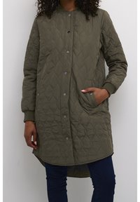 Kurtka pikowana w oliwkowym kolorze z okrągłym dekoltem, zatrzaskami i bocznymi kieszeniami. Długie rękawy z ściągaczami i zaokrąglonym dołem.