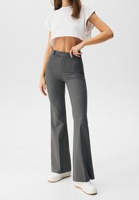 Grijze uitlopende broek van textuurstof met een middelhoge taille en een slim fit door het been, eindigend in een brede flared zoom.