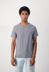 Gestreepte crew-neck t-shirt in blauw en wit, korte mouwen, zachte katoen materiaal, lichte textuur, ontspannen pasvorm, gecombineerd met lichtdenim jeans.