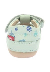 Sandaña infantil de color verde claro con un patrón de medusas, material de cuero suave, correa ajustable y suela de goma marrón con costuras.