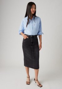 Light blue button-up shirt paired with a black denim midi skirt. The skirt features a fitted design and subtle fading, with a matching black belt.