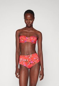 Rød blomsterbikini-sett som har en stroppeløs topp med en strukturert design og høy-tali bukser med en glatt tekstur og fargerik mønster.