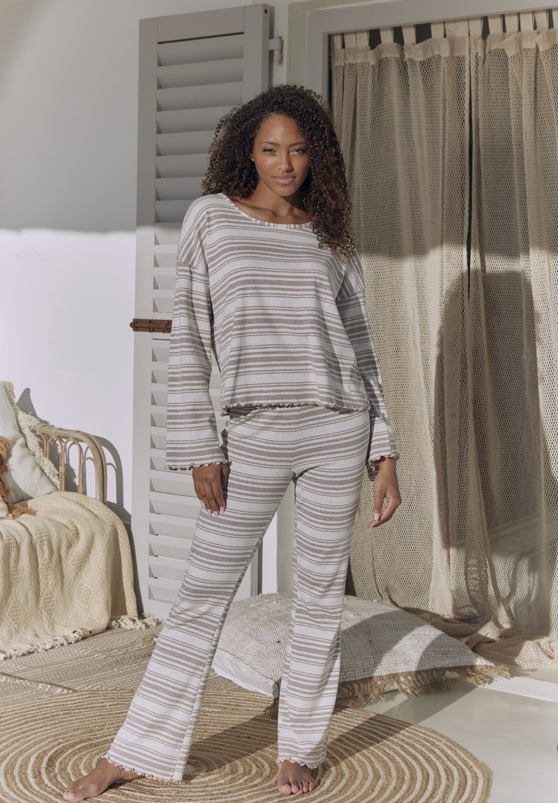 Gestreiftes Lounge-Set aus weichem Stoff mit langen Ärmeln, rüschierten Säumen und einer lässigen Passform in neutralen Farbtönen von Beige und Braun.